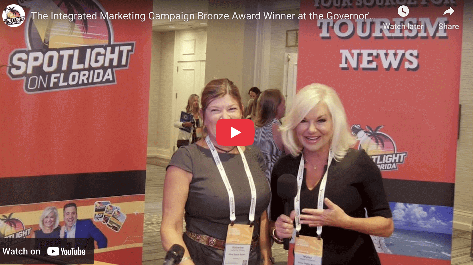 Two women posing at marketing event.