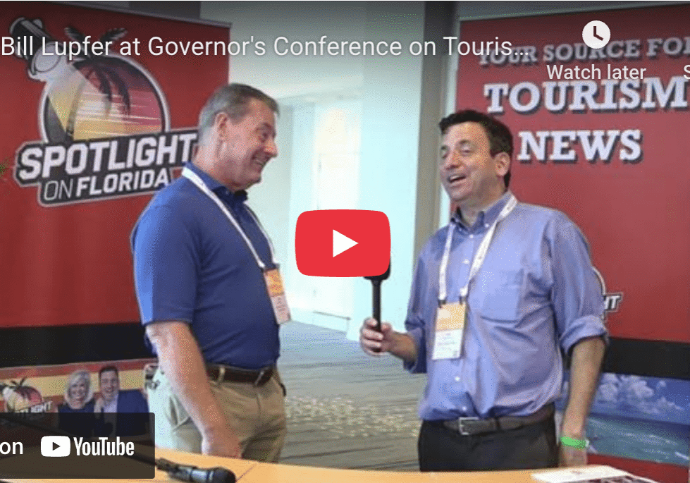 Two men talking at tourism conference booth.